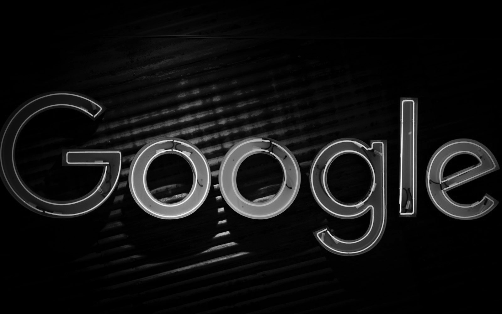 Karanlık zeminde renkli neon Google logosu